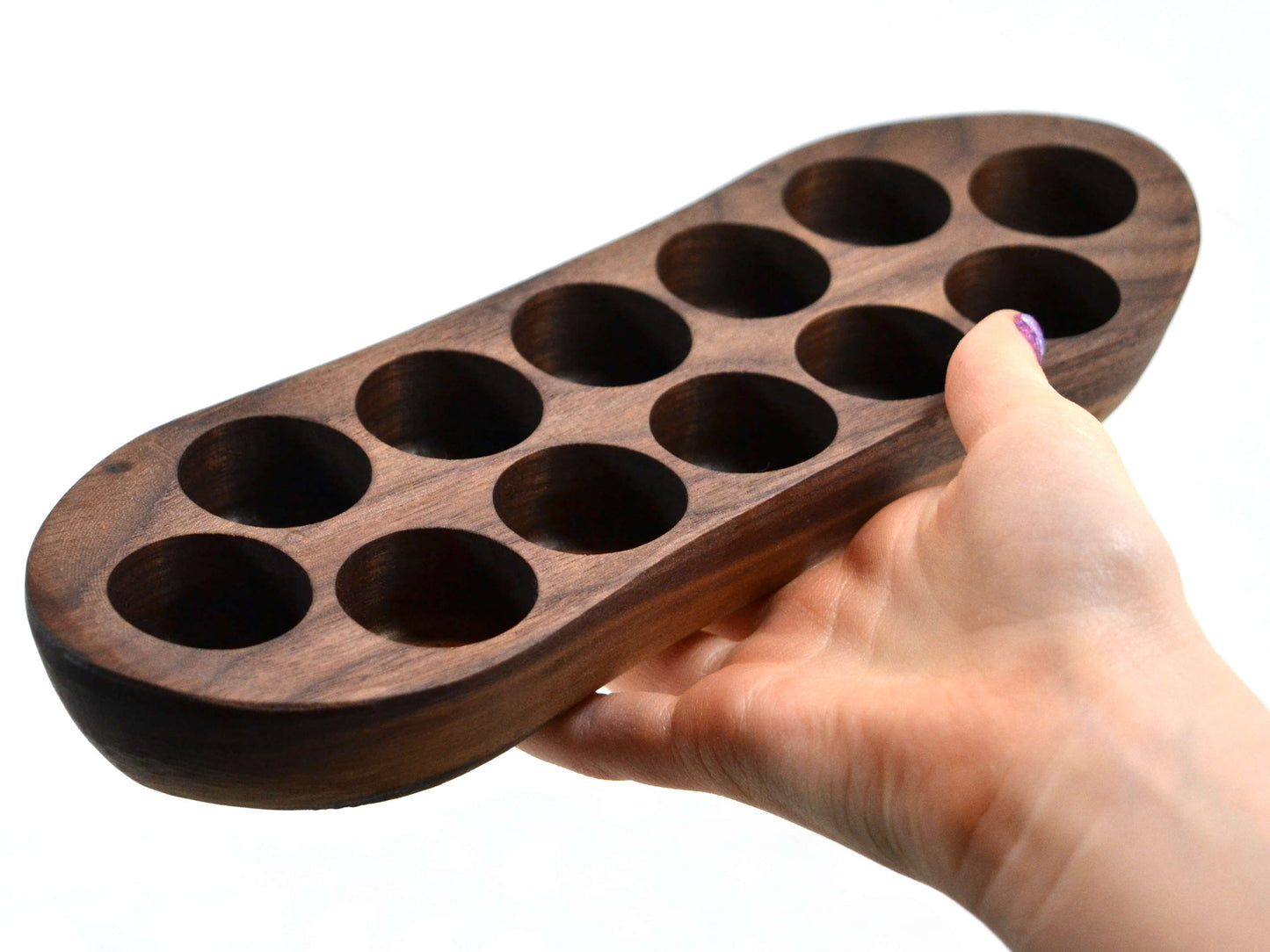 holding a small cute walnut wood essential oil display rack for a dozen oils