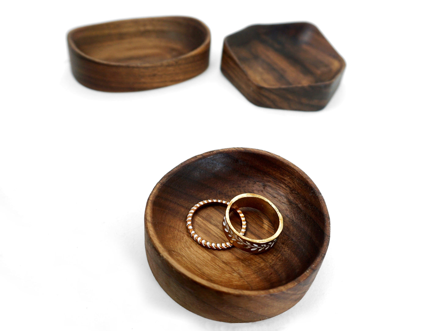 circular walnut wood ring dish with rings and other geometric themed trays