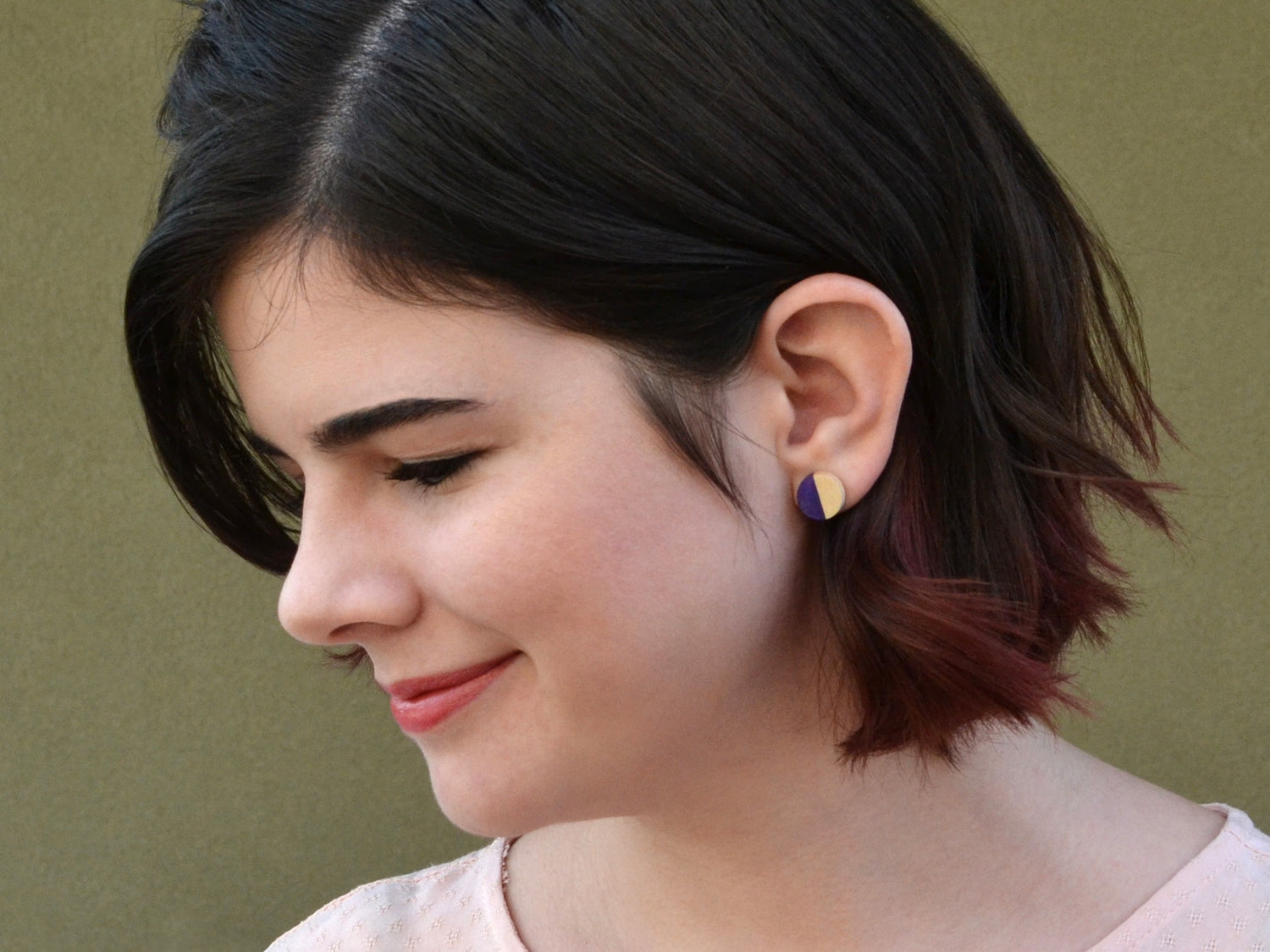 girl wearing half moon maple and purple stud earrings